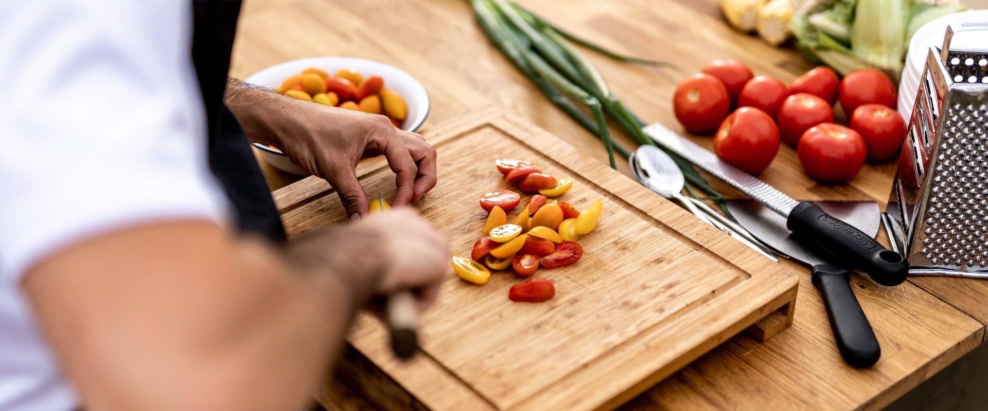 Gemüse wird auf Holzbrett geschnitten