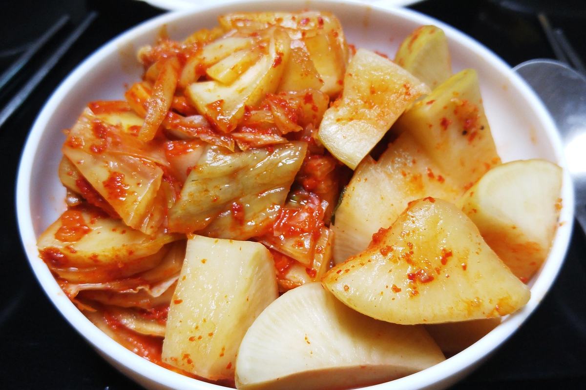 Schale mit Kimchi aus Chinakohl und Rettichstücken in roter Chilipaste