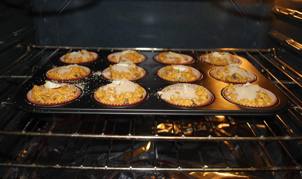 Muffinblech mit zwölf Muffins auf dem Rost im Backofen