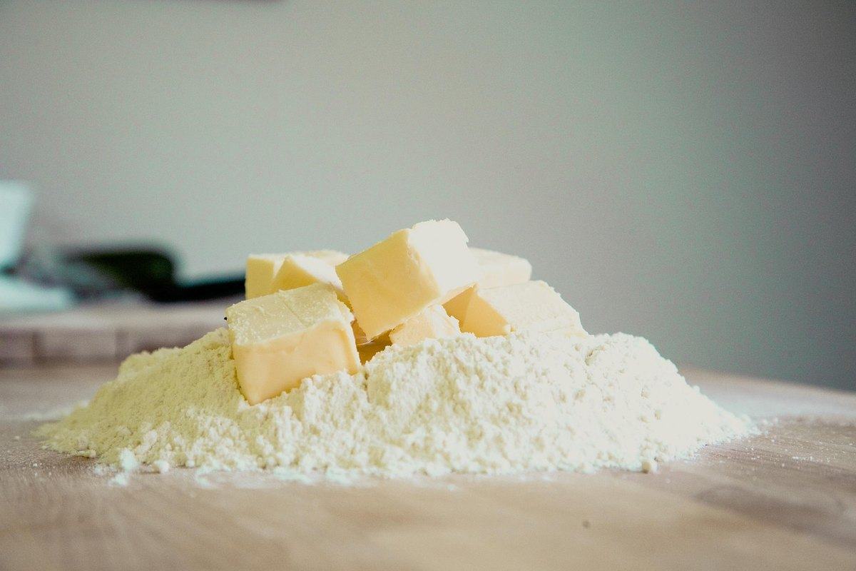 Würfel kalter Butter auf einem Häufchen Mehl auf einer Holzplatte